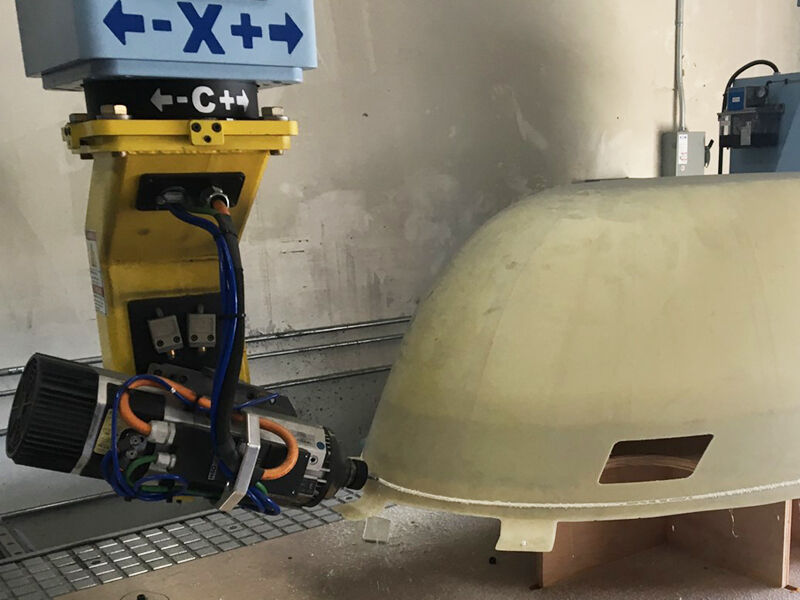 Image shows X-band belly radome being cut in a 5-axis CNC machine. 